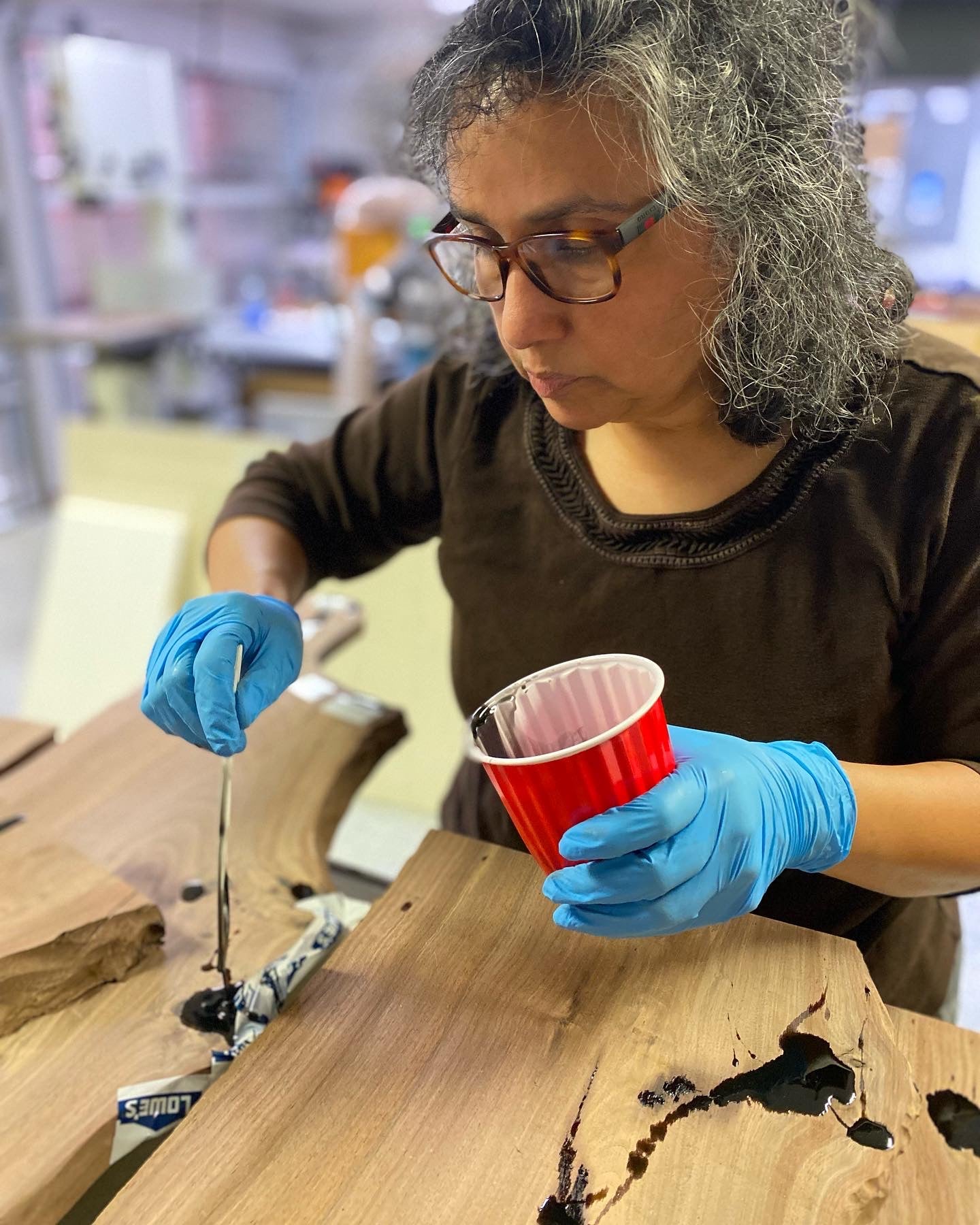 Person working on handmade furniture in a workshop, illustrating handmade furniture vs mass-produced furniture.