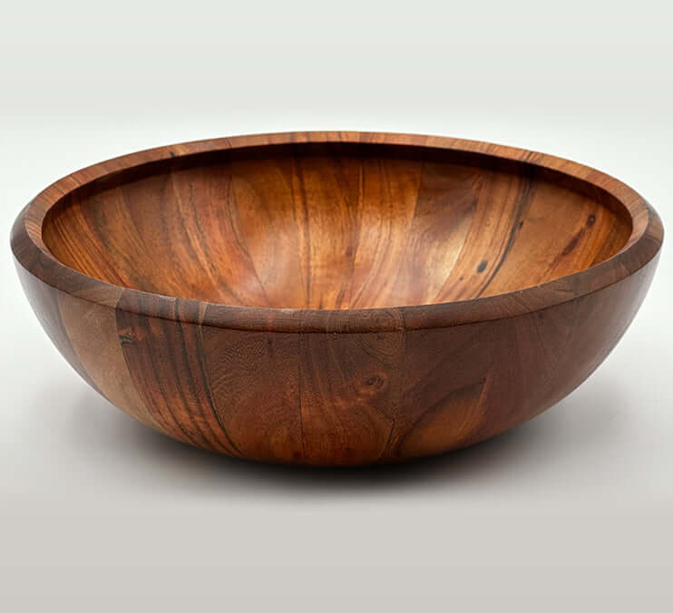 Hand carved acacia bowls showcasing rich grain and warm tones, perfect for serving and decor.