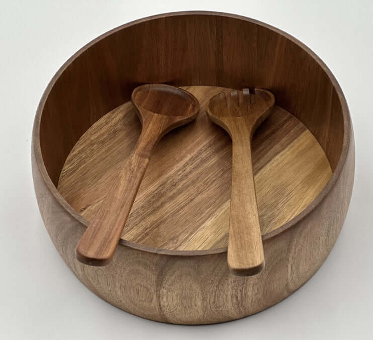 Hand carved acacia bowls with wooden serving utensils highlighting the unique grain of the wood.