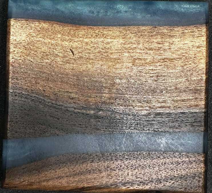 Black walnut coasters with blue epoxy showcasing rich wood grains and vibrant epoxy inlays.