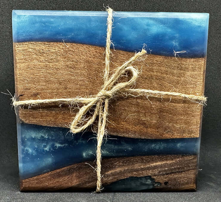 Black walnut coasters with blue epoxy beautifully arranged and tied with twine, showcasing natural wood and vibrant epoxy.