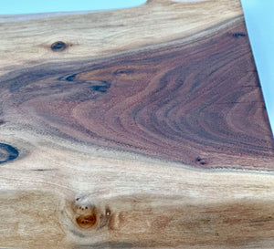 Close-up of the surface of a Live Edge Walnut Charcuterie Board showcasing unique wood grain patterns.
